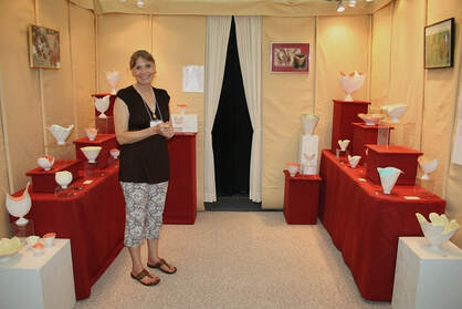 Antoinette Badenhorst shows her porcelain translucent bowls, envelopes and sculptures in her show booth.